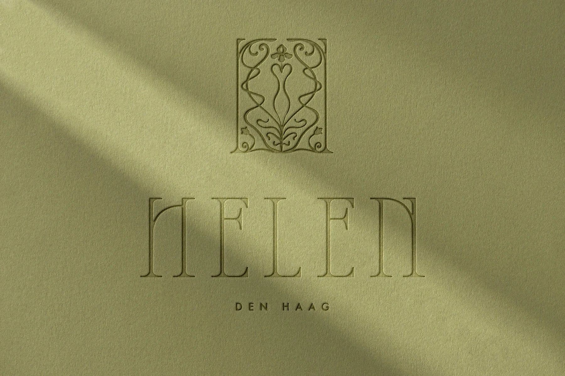 Helen embossed emblem and wordmark on olive paper